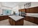 A spacious kitchen features a central island, stainless appliances and light countertops at 1673 E Laddoos Ave, Queen Creek, AZ 85140