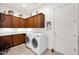 Laundry room featuring front load washer and dryer, storage, and tile flooring at 1673 E Laddoos Ave, Queen Creek, AZ 85140