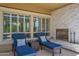 Relaxing outdoor patio with lounge chairs, a fireplace, and ample natural light from large windows at 1673 E Laddoos Ave, Queen Creek, AZ 85140