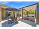Inviting covered patio with comfortable seating, ceiling fan, and outdoor dining area with a large umbrella at 1673 E Laddoos Ave, Queen Creek, AZ 85140