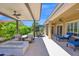 Spacious covered patio boasts a fire pit, lounge chairs, and views of the landscaped backyard at 1673 E Laddoos Ave, Queen Creek, AZ 85140