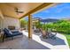 Expansive patio includes an outdoor fireplace, lounge chairs, dining set, and landscaped yard at 1673 E Laddoos Ave, Queen Creek, AZ 85140