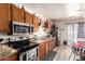 Charming kitchen featuring wood cabinets, modern appliances, and a cozy dining area with black and white accents at 18217 N 34Th Ave, Phoenix, AZ 85053