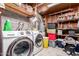 Functional laundry area with modern washer and dryer, ample storage, and exposed brick walls at 18217 N 34Th Ave, Phoenix, AZ 85053