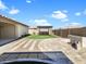 Landscaped backyard featuring an outdoor firepit, pergola, gravel walkway, and well-maintained artificial turf at 18389 W Long Lake Rd, Goodyear, AZ 85338