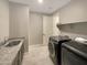 Well-lit laundry room boasts granite counters, ample cabinet space, and modern, high-efficiency appliances at 18389 W Long Lake Rd, Goodyear, AZ 85338
