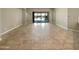 Empty room with tiled flooring and a large glass sliding door leading to an outdoor space at 18389 W Long Lake Rd, Goodyear, AZ 85338