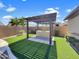 Stylish backyard pergola featuring a built-in barbecue and manicured artificial turf for outdoor entertaining at 18389 W Long Lake Rd, Goodyear, AZ 85338