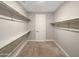 Spacious walk-in closet providing ample storage with built-in shelving and neutral carpeting at 18389 W Long Lake Rd, Goodyear, AZ 85338