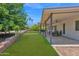 Expansive backyard with lush lawn, covered patio, and a charming retaining wall at 2607 E Mercer Ln, Phoenix, AZ 85028