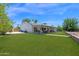 Expansive backyard with a lush lawn, covered patio, and mature landscaping, designed for outdoor entertainment and relaxation at 2607 E Mercer Ln, Phoenix, AZ 85028