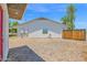 Spacious backyard featuring a white house with a long, covered patio, and gravel landscaping, offering functionality and charm at 2607 E Mercer Ln, Phoenix, AZ 85028