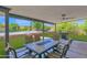 Covered backyard patio with an outdoor dining area and view of the pool and lush greenery at 2607 E Mercer Ln, Phoenix, AZ 85028