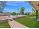 Landscaped backyard featuring a pool, a green lawn, and mature trees, offering a beautiful outdoor retreat at 2607 E Mercer Ln, Phoenix, AZ 85028