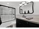 Updated bathroom featuring a shower, vanity, and decorative mirror, offering a modern and well-maintained space at 2607 E Mercer Ln, Phoenix, AZ 85028