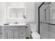 Modern bathroom featuring a glass shower, sleek vanity, and a large, illuminated mirror, offering a clean and stylish design at 2607 E Mercer Ln, Phoenix, AZ 85028