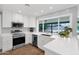 Modern kitchen featuring white cabinets, stainless steel appliances, quartz countertop, and a large window at 2607 E Mercer Ln, Phoenix, AZ 85028