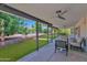 Covered patio overlooking a manicured lawn and swimming pool, offering a relaxing space for outdoor living at 2607 E Mercer Ln, Phoenix, AZ 85028