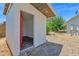 Exterior of a modern shed with a red door, situated in a backyard with gravel and mature trees, blending storage and style at 2607 E Mercer Ln, Phoenix, AZ 85028