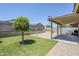Backyard featuring a covered patio area, beautiful landscaping, and a swing set for outdoor fun and relaxation at 2717 W Bowker St, Phoenix, AZ 85041