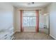 Cozy bedroom features a sunny window with curtains, plush carpeting, and a full-length mirror for added convenience at 2717 W Bowker St, Phoenix, AZ 85041