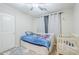 Bright bedroom with a ceiling fan, a bed with drawers, and a crib at 2717 W Bowker St, Phoenix, AZ 85041