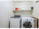 A laundry room with a washer, dryer, and storage shelf at 2717 W Bowker St, Phoenix, AZ 85041