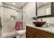 Well-lit bathroom with a glass shower, modern vanity with granite countertops, and decorative mirror at 2749 W San Juan Ave, Phoenix, AZ 85017