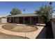 View of a home's backyard with a covered patio and unique landscaping for a tranquil outdoor living space at 3006 W Stella Ln, Phoenix, AZ 85017