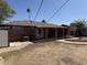 View of a home's backyard featuring a covered patio, landscaping, and seamless indoor-outdoor living at 3006 W Stella Ln, Phoenix, AZ 85017