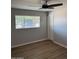 Bright bedroom features a large window, ceiling fan and updated flooring for comfort at 3006 W Stella Ln, Phoenix, AZ 85017