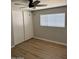 Bedroom with wood flooring, a ceiling fan, window, and sliding door closet, offering great storage at 3006 W Stella Ln, Phoenix, AZ 85017