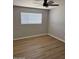 Cozy bedroom featuring wood flooring, a ceiling fan, and a bright window with outside view at 3006 W Stella Ln, Phoenix, AZ 85017