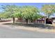 Quaint brick home with a white picket fence, surrounded by mature shade trees and a well-maintained yard at 3006 W Stella Ln, Phoenix, AZ 85017