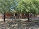 Brick house with decorative white fence and mature trees offering shade and curb appeal at 3006 W Stella Ln, Phoenix, AZ 85017