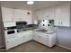 Functional kitchen featuring white cabinets, tile backsplash, and tile floors for easy maintenance at 3006 W Stella Ln, Phoenix, AZ 85017