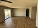Open-concept living room with sleek wood flooring and sliding glass doors that provide backyard access at 3006 W Stella Ln, Phoenix, AZ 85017