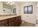 Well-lit bathroom featuring a granite counter, dark wood cabinet, and shower-tub combo at 3529 W Saint Moritz Ln, Phoenix, AZ 85053