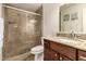Bathroom featuring tiled shower with glass doors, granite counter and dark cabinets at 3529 W Saint Moritz Ln, Phoenix, AZ 85053