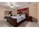 Spacious bedroom with carpet, ceiling fan, and large framed bed with matching nightstand at 3529 W Saint Moritz Ln, Phoenix, AZ 85053