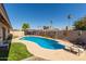 Backyard pool featuring a diving board, lounge chairs and green lawn at 3529 W Saint Moritz Ln, Phoenix, AZ 85053