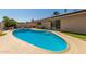 This backyard pool has stair-step access, desert landscaping, and access to the home through sliding glass doors at 3529 W Saint Moritz Ln, Phoenix, AZ 85053