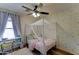 A bedroom with a white canopy bed frame, sprinkle wallpaper, and a desk near the window at 4199 E Citrine Rd, San Tan Valley, AZ 85143