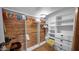 Walk-in closet with custom shelves, clothing racks, and wood paneling with a view of the hardwood floors at 426 E Carol Ann Way, Phoenix, AZ 85022