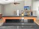 Modern kitchen island with granite countertops, a ceiling fan and a TV at 45726 W Long Way, Maricopa, AZ 85139