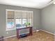 Bright living room with view of pool from window with wooden shutters at 45726 W Long Way, Maricopa, AZ 85139