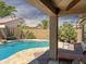 Private backyard with sparkling pool, lush palm trees, and covered patio perfect for outdoor entertaining at 45726 W Long Way, Maricopa, AZ 85139
