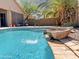 Backyard pool featuring rock waterfall, and mature palm trees creating a perfect space for relaxation at 45726 W Long Way, Maricopa, AZ 85139