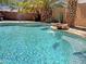 Stunning pool with stone waterfall feature, and lush palm trees creating a tranquil backyard retreat at 45726 W Long Way, Maricopa, AZ 85139