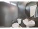 Elegant half bath featuring a pedestal sink, stylish mirror, and neutral color scheme at 4712 E Bonanza Rd, Gilbert, AZ 85297